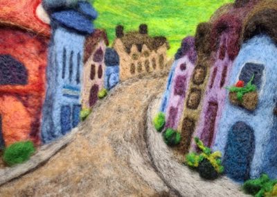 Needle felted village street with plants and planters along the street