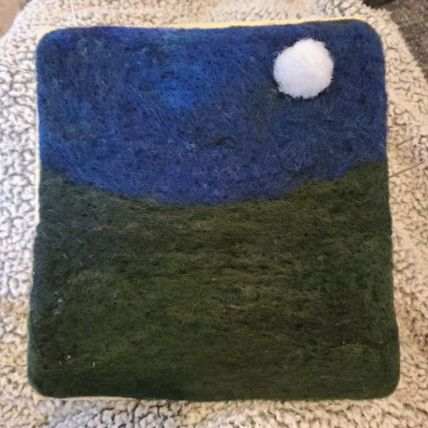 Once the sky is firmly felted in place, also wrapping the edes around to the back of the base, place a small moon in the picture.